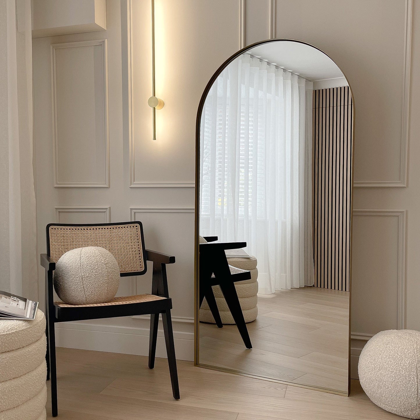 Full length arched Dourado large metal mirror leaning against wall