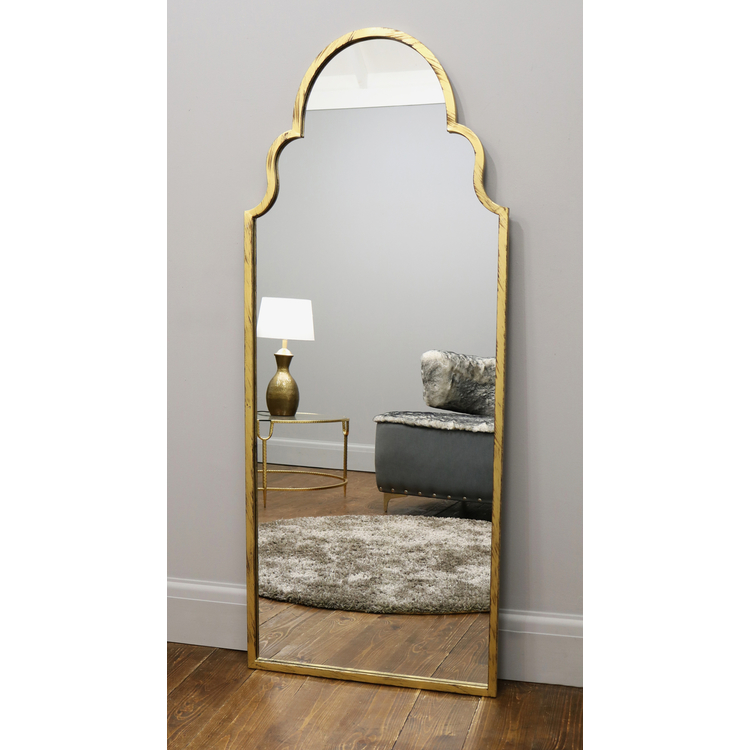 Dourado industrial arched large metal mirror leaning against wall