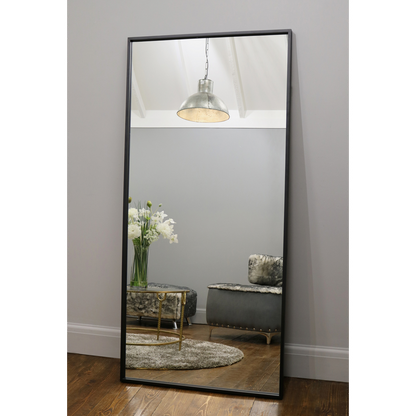 Full Length Black Industrial Metal Mirror reflecting light in living room