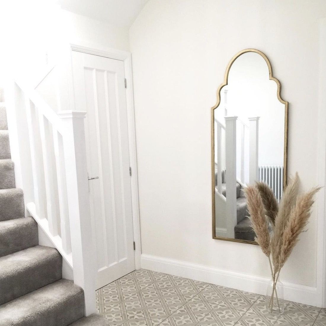 Dourado industrial arched extra large metal mirror displayed on wall