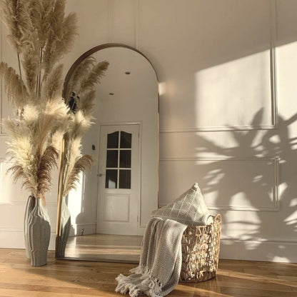 Full length arched Dourado large metal mirror leaning against wall